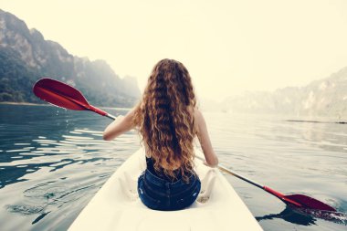 Milli Parkın içinden bir kano kürek çekmeye kadın