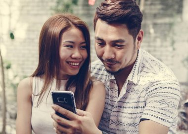 Genç çift birlikte bir telefon kullanma