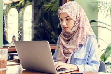 Oturma ve dizüstü bilgisayar kullanarak islam kadın 
