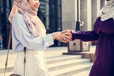 hijab açık havada el sıkışan iki islam kadın 