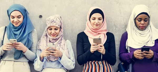 Grupo Mulheres Islâmicas Usando Telefones Inteligentes Perto Parede Cinza — Fotografia de Stock