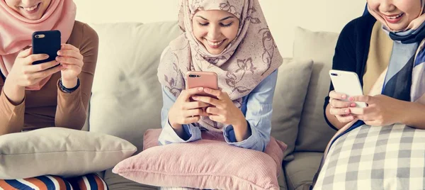 Grupo Mulheres Islâmicas Sentadas Sofá Usando Telefones Inteligentes — Fotografia de Stock