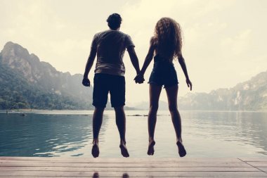 Arkadan Görünüş waterside üzerinde atlama çift