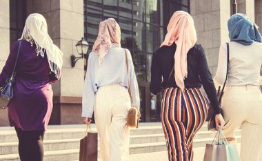 Arkadan görünüm kadınların burka alışveriş torbaları ile yürüyüş 