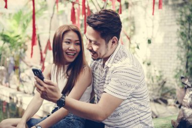 Genç çift birlikte bir telefon kullanma