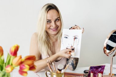 Beauty blogger showing face chart with makeup sample clipart
