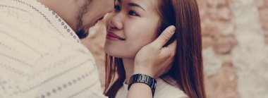 Bir tuğla duvar tarafından güzel Asyalı Çift