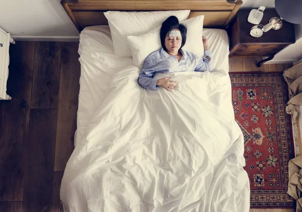 生病的亚洲妇女发烧睡在床上 — 图库照片