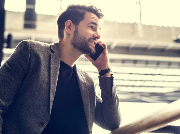 Adam telefonda konuşuyor.