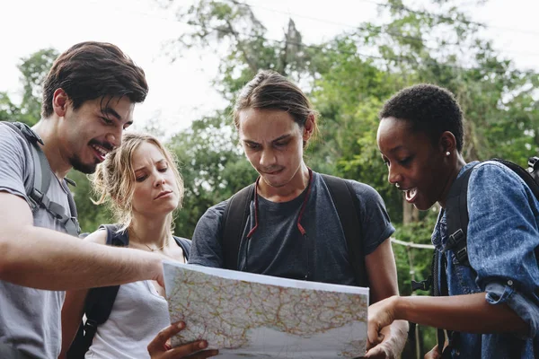 Group of friends looking at a map together travel and teamwork concept