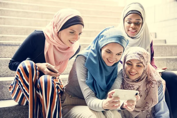 看智能手机的伊斯兰妇女小组 — 图库照片