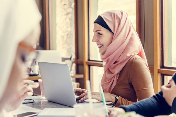 Islamic women discussing and using laptop for working 