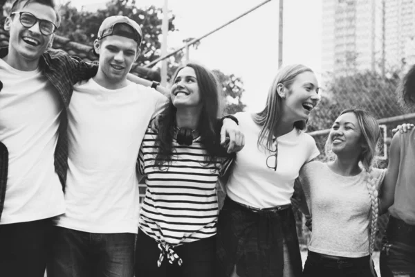 在户外友谊和联系的概念下 快乐的年轻的成年朋友们拥抱着肩膀微笑 — 图库照片