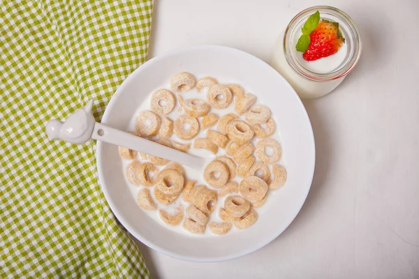 Loops de cereais deliciosos e nutritivos em uma tigela com leite para café da manhã saudável para crianças — Fotografia de Stock