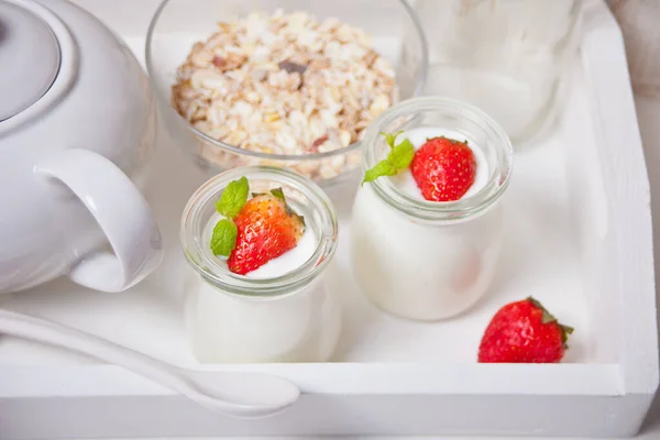 Dos porciones de yogur casero natural en un frasco de vidrio con fresa fresca y muesli cerca — Foto de Stock