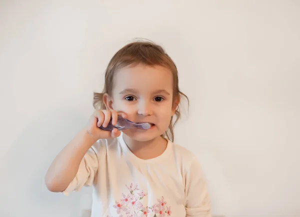 Pouco bonito menina smailing e escovar os dentes . — Fotografia de Stock