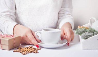 Bir kadının çay bardağını tutması. Sıcak ve sıcak bir atmosfer. Arka planda Noel dekoru