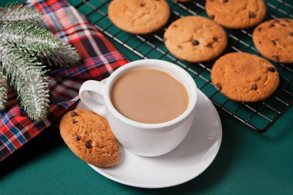 Cup of tea, homemade cookie, Christmas gift boxes and Christmas decor on the green background. — Stock Photo, Image