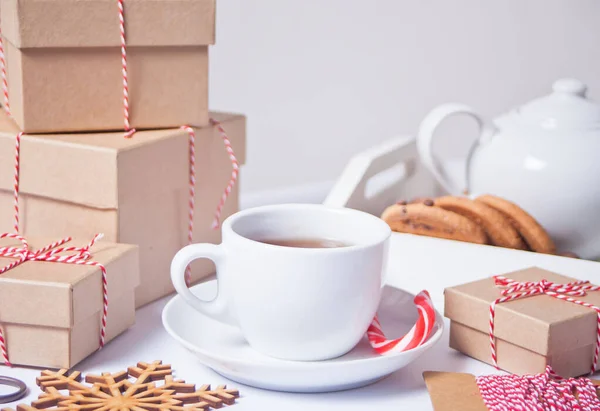 Egy csésze tea, házi sütik, karácsonyi ajándékdobozok és karácsonyi dekoráció a fehér háttér. — Stock Fotó