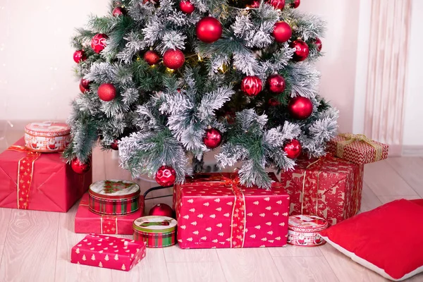 Arbre de Noël décoré avec de nombreux coffrets cadeaux à proximité — Photo