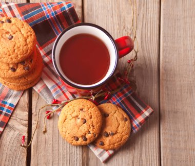 Kırmızı fincanlı kurabiyeler sıcak çay ya da ahşap masada kahve.