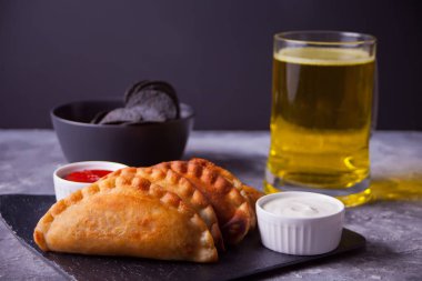 Meksika mısır cipsi nachos, kızarmış etli börek börek soslu cheburek ve bir bardak bira. Acımasız erkekler için siyah cips..