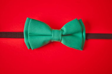 Kırmızı arka planda yeşil kravat kelebeği.