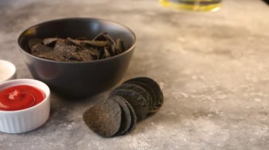 Beton masaya cam kadın birası ve kovboy şapkası ile Meksika mısır cipsi ve soslu cips koydum. Acımasız erkekler için siyah cips..