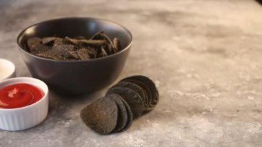 Elinle beton masaya bir bardak bira koy. Yanında Meksika mısır cipsi ve soslu cips. Acımasız erkekler için siyah cips..