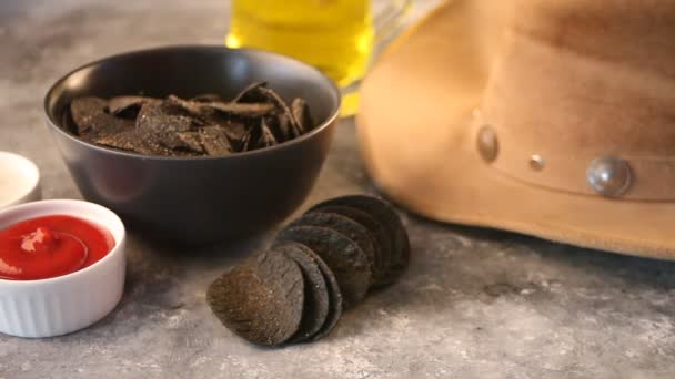 Mano de mujer toma nachos de patatas fritas mexicanas negras y se sumerge en una salsa de pausa . — Vídeos de Stock