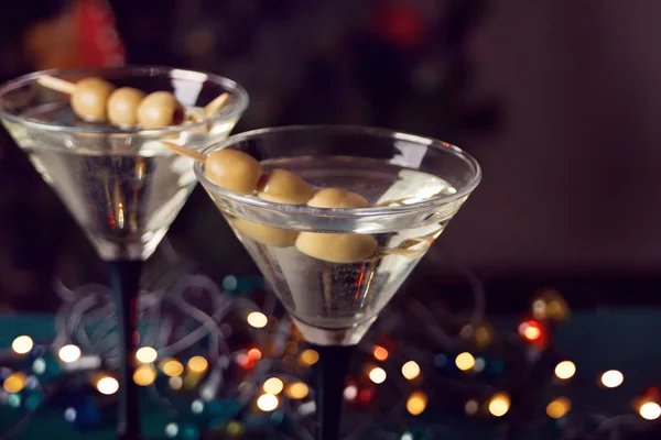Due bicchieri di martini con olive e ghirlanda leggera con bokeh sullo sfondo — Foto Stock
