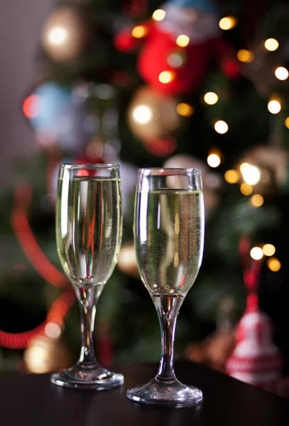 Dos copas de champán cerca del árbol de Navidad con bokeh — Foto de Stock