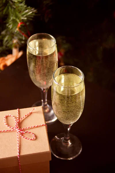 Dos copas de champán y caja de regalo en el fondo oscuro — Foto de Stock