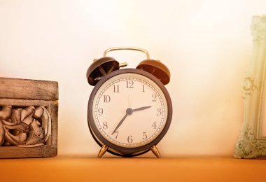 Ahşap rafta antika bir çalar saat var..