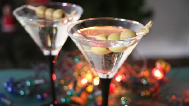 Két Pohár Martini Olajbogyóval Világos Koszorúval Bokeh Val Háttérben — Stock videók