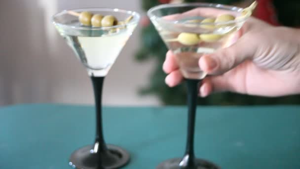 女人的手放在蓝色的桌子上 放了一杯配橄榄的马提尼 — 图库视频影像