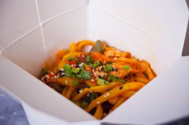 Udon eriştesi ve karton kutuda tavuk eti. Açılmış paket kutusu.