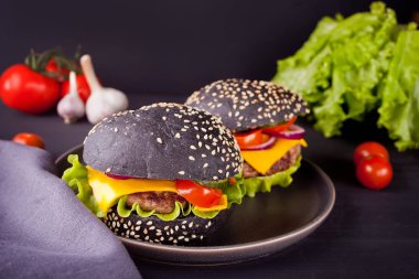 Tabakta pirzola ve sebzeli ev yapımı siyah hamburgerler