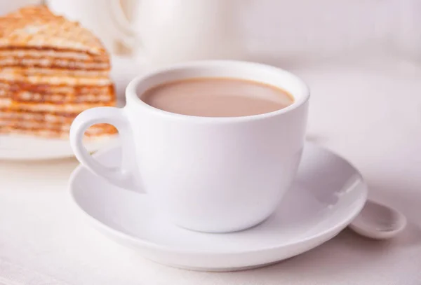 Una taza de café y un pedazo de pastel de gofres en la mesa blanca . — Foto de Stock