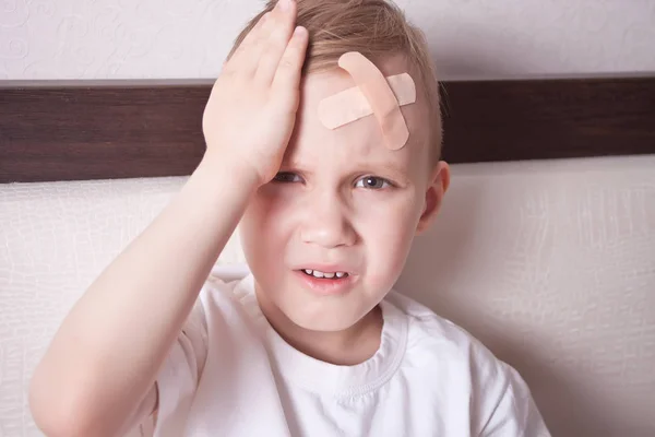 Liten gutt med gips på hodet og ikke føler seg bra . – stockfoto