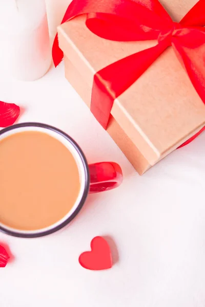 Cup of coffee and a heart shaped red cookie with gift box on the white table — Stock Photo, Image