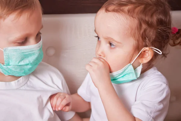 소년과 소녀, 의료 용 마스크를 쓴 아이들. 전염병, 인플루엔자, 질병으로부터의 보호, 예방 접종의 개념. — 스톡 사진
