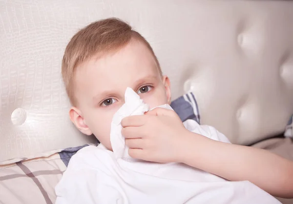 Sick little blond boy blowing her nose — Stock Photo, Image