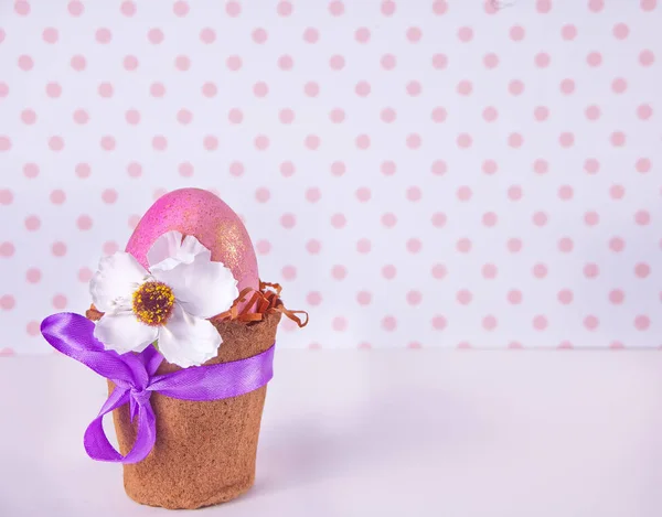 Oeuf rose de Pâques dans un pot sur le fond à pois — Photo