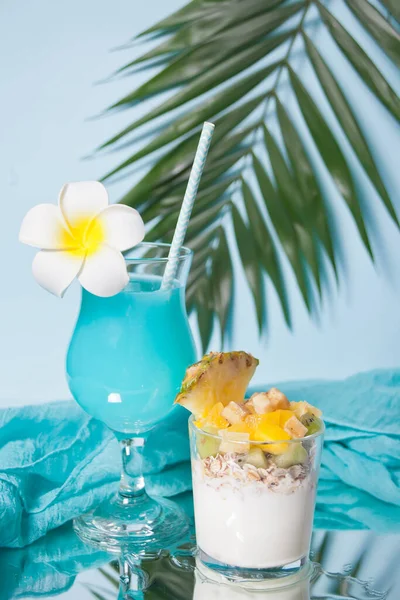 Exotic tropical fruit salad with muesli and yogurt in a glass with blue cocktail. — 스톡 사진