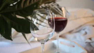 Kadın eli cam üzümlü şaraba dökülüyor. Romantik yemek konsepti