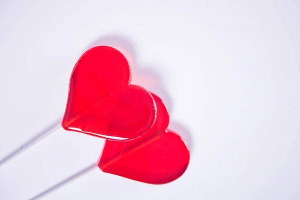 Twee rode hartvormige lolly 's snoep voor Valentijnsdag. Bovenaanzicht. Kopieerruimte. — Stockfoto