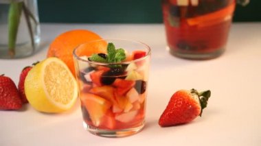 Kadın eli kırmızı şarap koydu taze sangria ya da meyveli meyve ve meyveli punç..