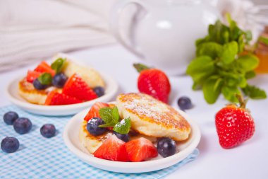 İki tabak süzme peynirli krep şurubu, böğürtlen ve pudra şekerli..