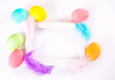 Çerçeve, Paskalya günü için renkli yumurta ve tüyler. Üst Manzara. Boşluğu kopyala